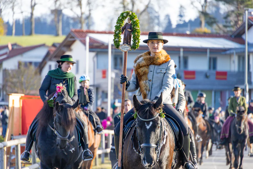 Reiter in Tracht mit Kranz und Stab